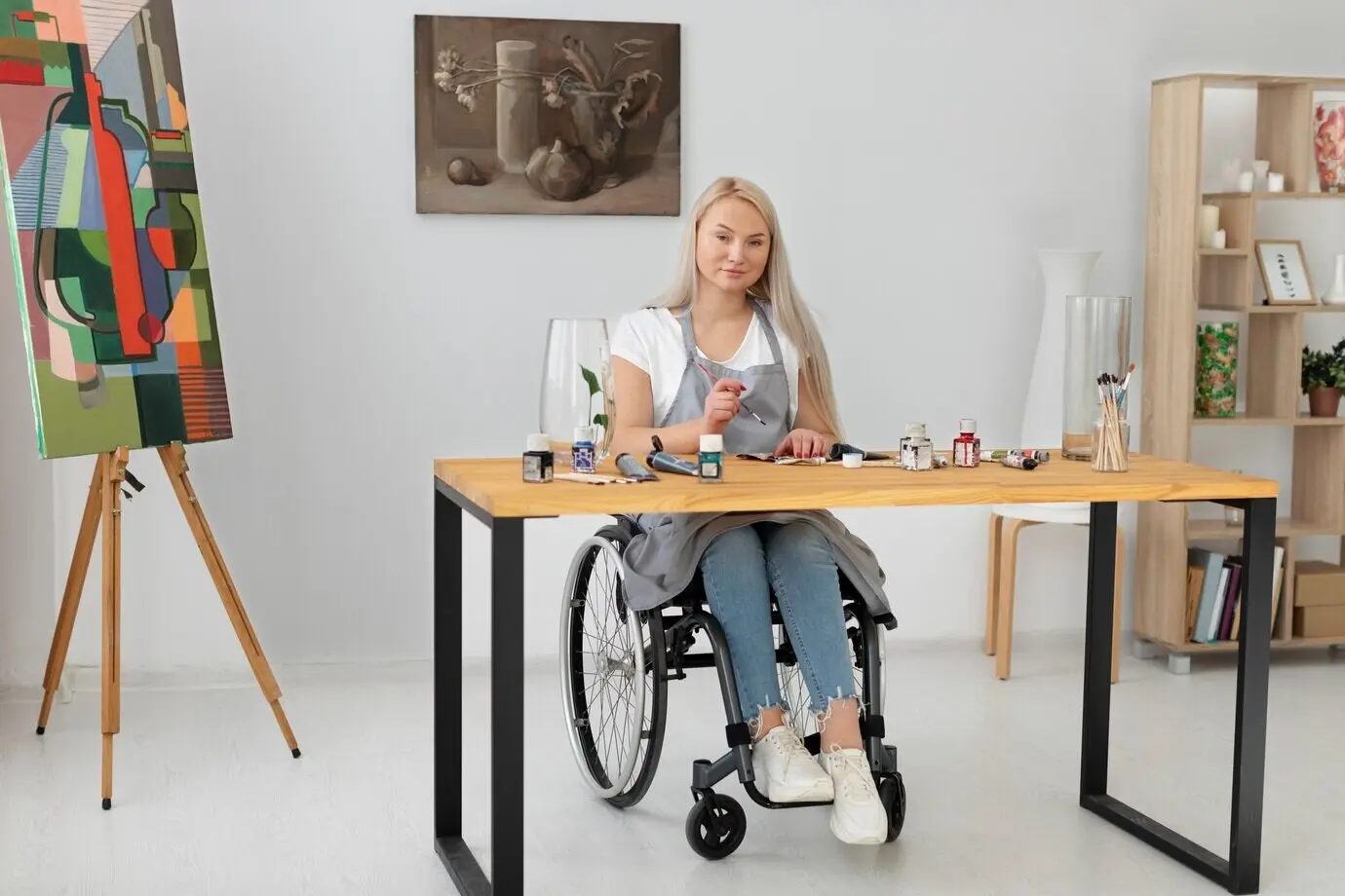 A disabled individual in a wheelchair, painting